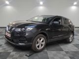 La Nissan QX-V noire est garée sur un sol en carrelage à damier.