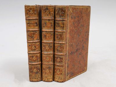 deux vieux livres sont empilés l'un sur l'autre sur une surface blanche