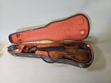 a violin in a case on a table next to a cup of coffee