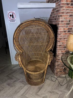 un fauteuil en osier près d'une cheminée en briques dans un salon