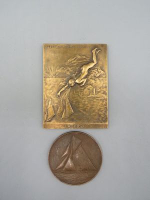 une petite médaille en bronze sur laquelle est représenté un oiseau