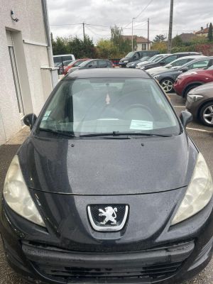 l'avant d'une voiture noire garée sur un parking à côté d'un immeuble