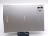 a silver cell phone on a stand on a white surface