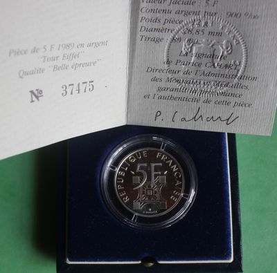 a silver coin in a blue box on a green surface