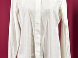 white shirt on a mannequin stand against a red background