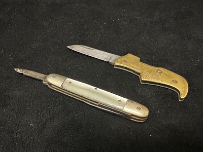 une paire de couteaux de poche anciens sur fond noir