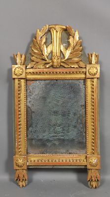 un cadre doré sur lequel est posé un miroir, posé sur une surface grise