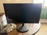 a computer monitor sitting on top of a wooden table