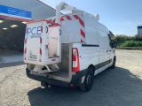 the back of a white van parked in front of a building