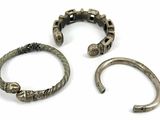 two silver bracelets and a bracelet with a ring on it