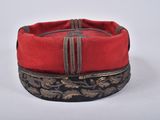 two red and black hats with gold trims on a white surface