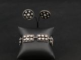 un gros plan sur une paire de boucles d'oreilles et un oreiller posés sur une surface noire