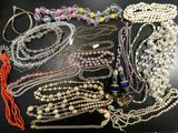 many different types of necklaces and bracelets on the table