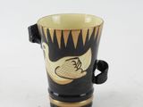 a black and gold coffee cup with a bird on it