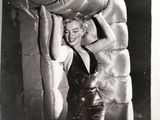 black and white photograph of a woman in a black dress holding a large pillow