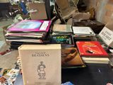 a lot of books on a table in a cluttered room