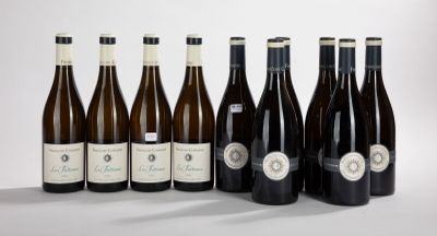 six bottles of wine are lined up in a row on a white surface