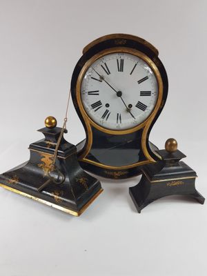 une horloge noire et dorée posée sur une table blanche