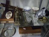 a glass table with a silver tray and a silver plate on it
