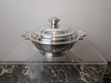 a silver plate with a glass lid on a marble table