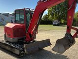 a red excavator that is sitting in the dirt