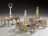 several pieces of silverware on a table with a clock in the background