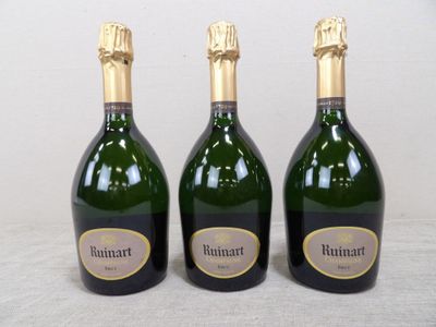 trois bouteilles de vin posées sur une table l'une à côté de l'autre