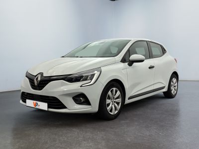 Une voiture blanche est garée dans une pièce au sol noir.