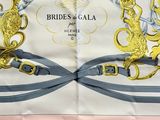 a close up of a scarf with a gold and silver design