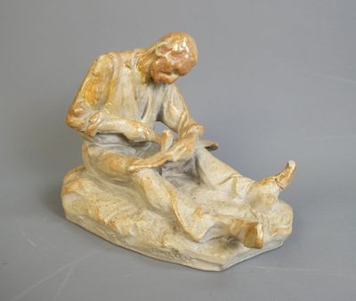 une figurine représentant un homme assis sur un rocher