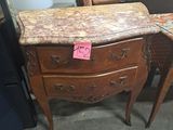 une table avec un plateau en marbre et deux chaises dans une pièce