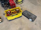 une caisse jaune contenant des outils, posée par terre