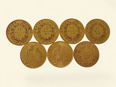 six pièces d'or sont disposées en ligne sur une surface blanche