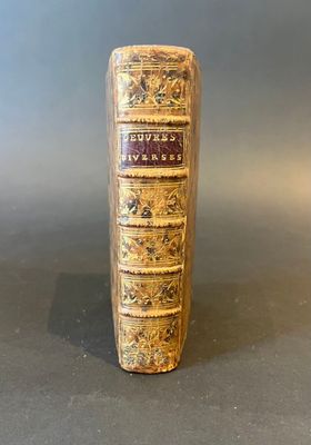 an old book sitting on top of a table next to a gray wall