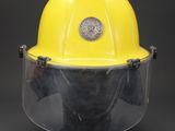 a close up of a yellow hard hat with a face shield