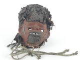 un masque en argile représentant un visage sur un fond blanc