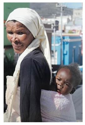 une femme portant un enfant sur le dos dans la rue