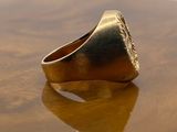 a close up of a gold ring on a wooden table