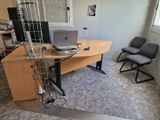 un bureau avec un ordinateur portable et une chaise dans un coin