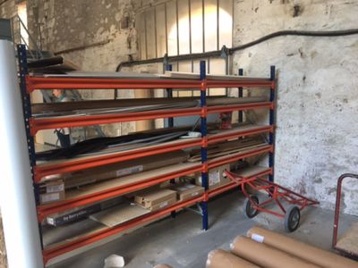 de nombreux rouleaux de papier kraft posés sur un rayonnage dans un entrepôt