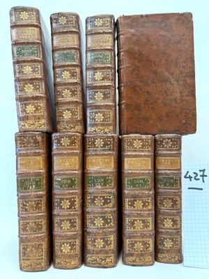 several old books stacked on top of each other on a table