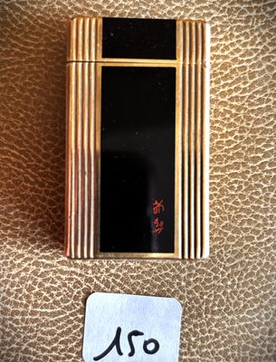 a picture of a gold cigarette case on a brown leather surface