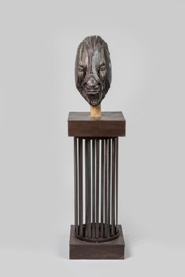 a close up of a sculpture of a lion head on a wooden stand