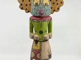 une image représentant une sculpture en bois d'une femme avec un papillon sur la tête