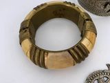 three pieces of jewelry are sitting on a white surface