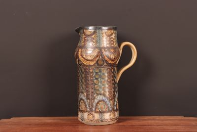 un vase marron et bleu posé sur une table en bois