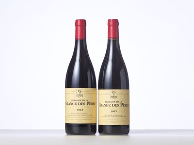 two bottles of red wine sitting on top of a table