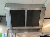 a stainless steel exhaust hood in a kitchen with a window