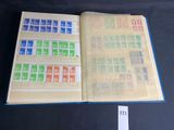 an open book with stamps on it sitting on a table