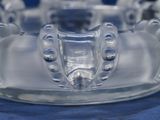 a clear glass bowl with a toothbrush holder on top of it